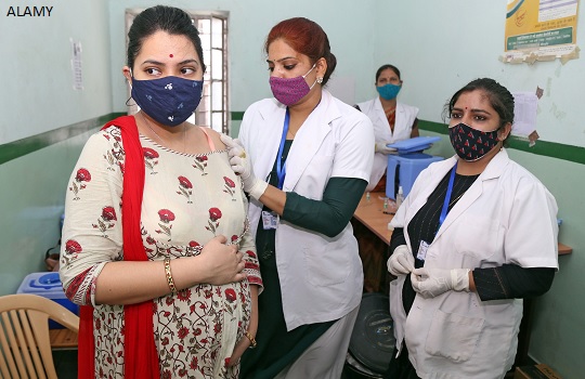 A pregnant woman is vaccinated against covid in India